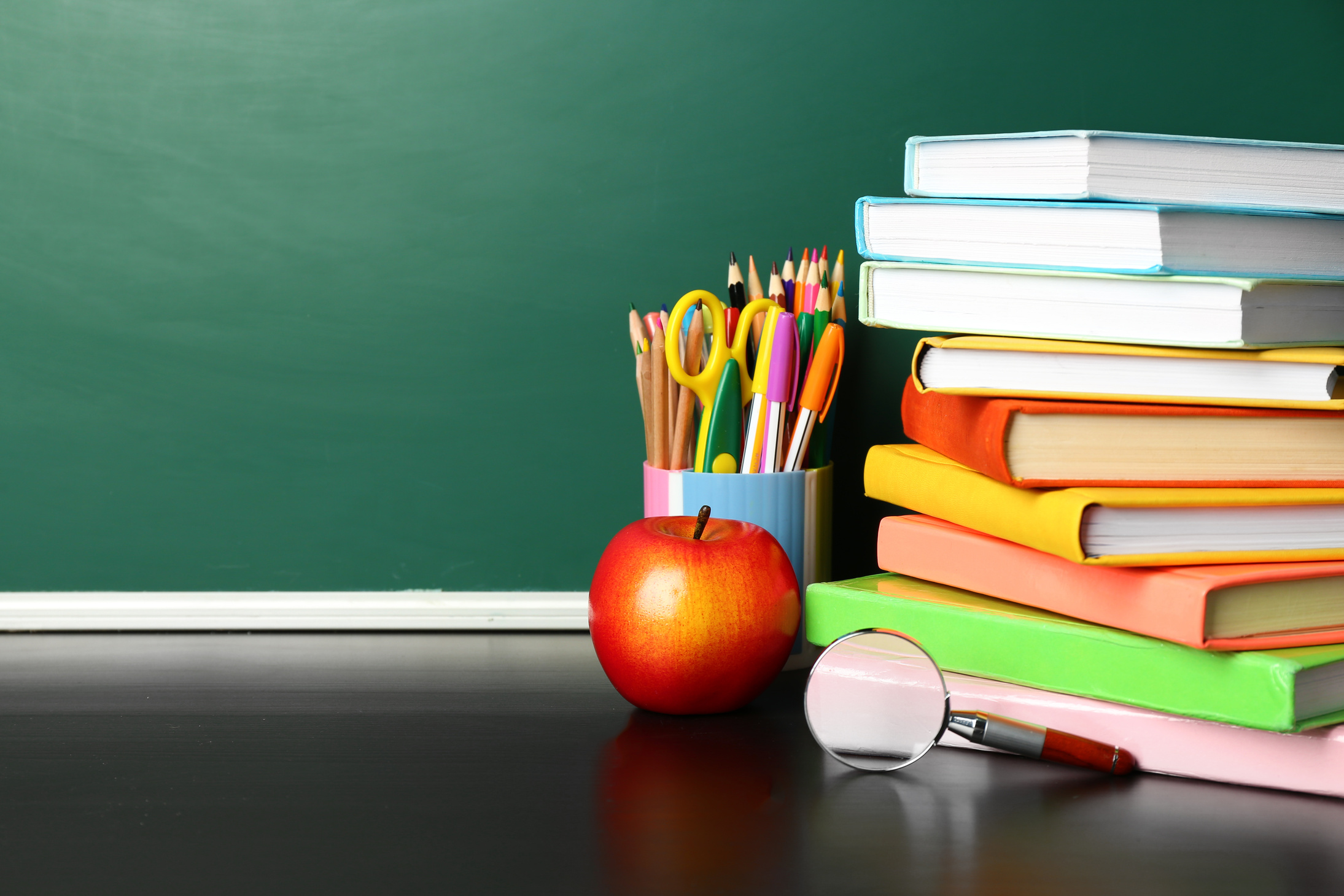 School Books on Desk near Chalkboard
